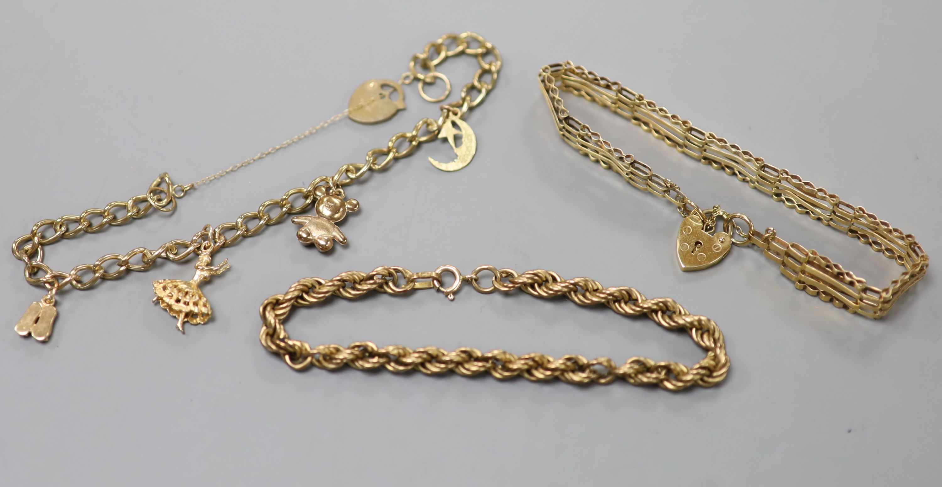 Three assorted modern 9ct gold bracelets, including charm and ropetwist